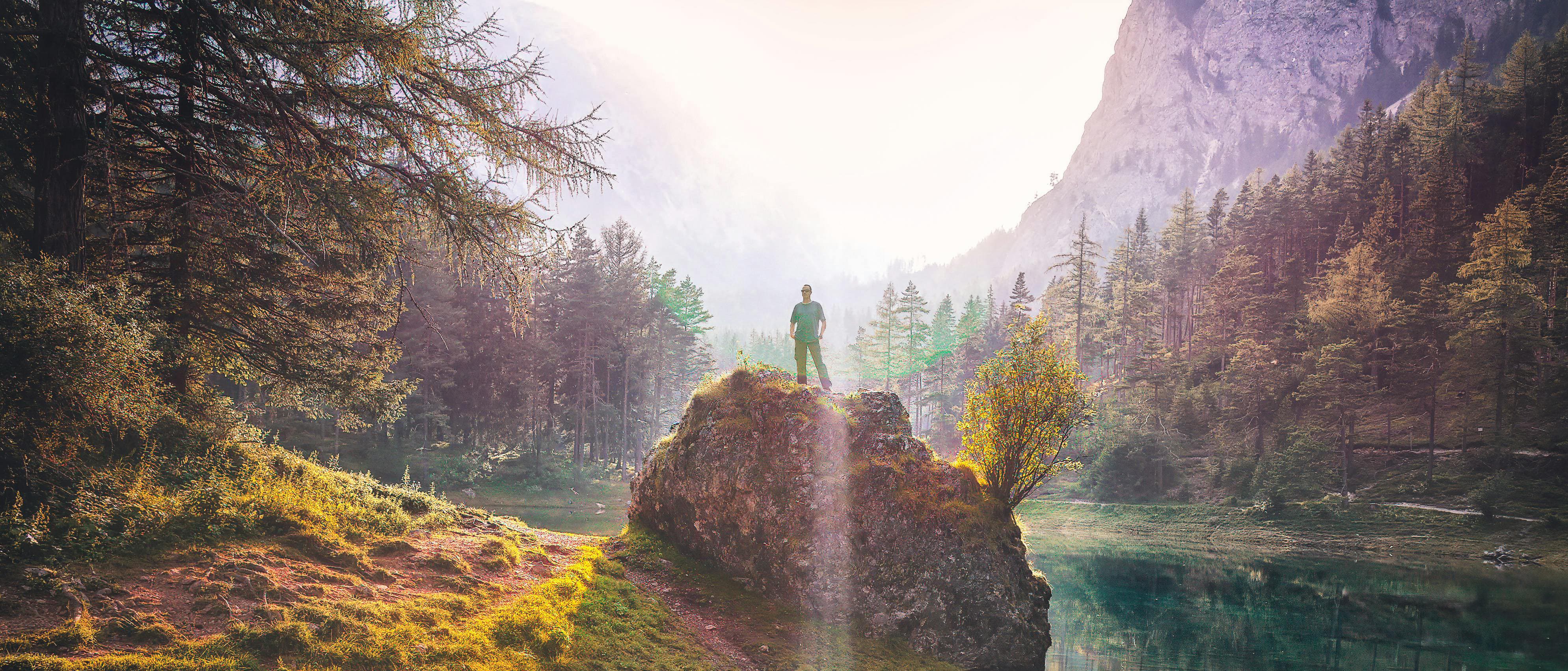 Man standing on a rock gazing into the distance.